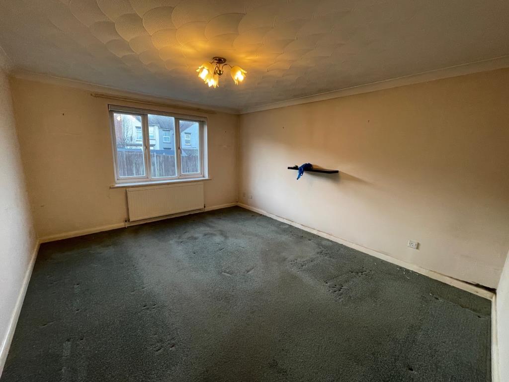 Lot: 99 - VACANT GROUND FLOOR ONE-BEDROOM FLAT IN ESSEX COASTAL TOWN - Living room with window to rear and radiator